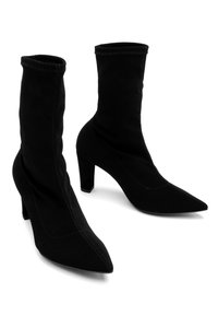 Czarne materiałowe botki za kostkę z wydłużonymi noskami i słupkowymi obcasami. Gładka tekstura z widocznymi detalami szwów po bokach.