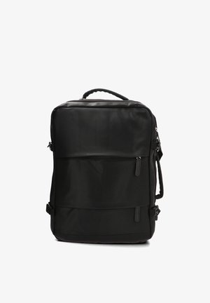 Mochila rectangular negra con asa superior, bolsillo frontal con cremallera, correas laterales y correas acolchadas para los hombros sobre un fondo blanco.
