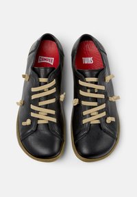 Black leather shoes with beige laces, featuring a round toe and rubber soles. Inside has red insoles labeled “CAMPER” and “TWINS.”