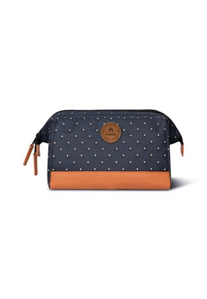 Sacchetto di stoffa blu con pois bianchi, fondo in pelle marrone, cerniera nera e emblema del logo davanti. Design compatto e rettangolare.