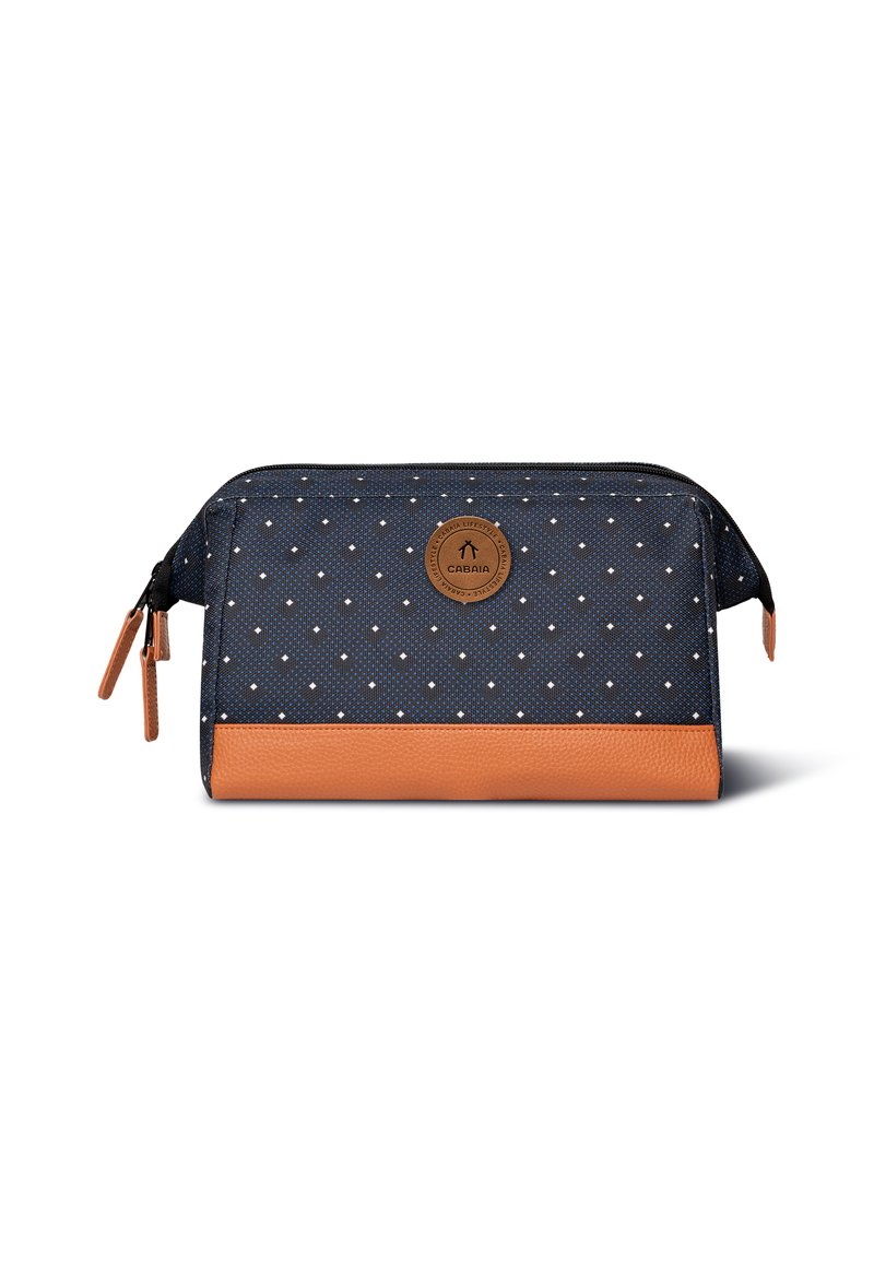 Sacchetto di stoffa blu con pois bianchi, fondo in pelle marrone, cerniera nera e emblema del logo davanti. Design compatto e rettangolare.