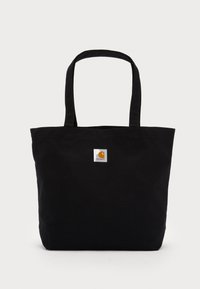Black canvas tote bag with two shoulder straps and a small square logo patch on the front, featuring a rectangular shape and sturdy construction.