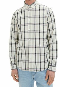 Camisa de manga larga en un beige claro con un patrón de cuadros en navy oscuro y rosa, con un cuellobutton-down y un bolsillo en el pecho.