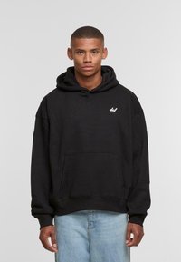 Black cotton hoodie with a kangaroo pocket, drawstring hood, and small white logo on the chest. Relaxed fit and ribbed cuffs.