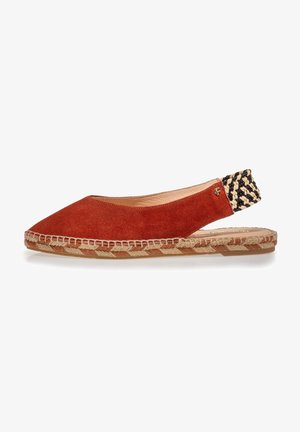 Chaussure slingback en daim rouge avec une bandoulière tissée noir et crème, semelle en corde de jute, bout pointu et coutures visibles le long des bords.
