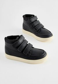 Chaussures montantes noires avec trois sangles réglables en Velcro, en matériau synthétique, semelle en caoutchouc et semelle intermédiaire blanche à finition texturée.