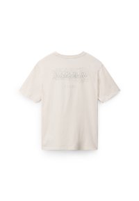 T-shirt en coton beige clair avec un imprimé graphique au dos représentant des coordonnées et un design texturé. Manches courtes, col rond.