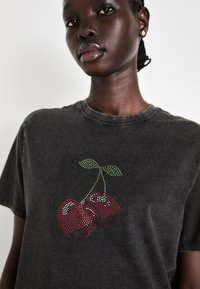 Grå bomull t-skjorte med et kirsebærmotiv i røde og grønne rhinestones, med klassisk rund hals og korte ermer.
