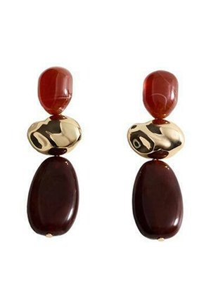 Cercei roșii și aurii, cu două pietre rotunjite roșii, un accent auriu cu un model ondulat și două pietre ovale roșii închise dedesubt.