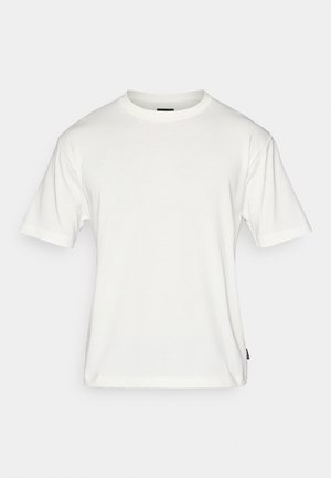 T-shirt blanc en coton, avec des manches courtes, un col rond à côtes et un ourlet droit. Texture légère et lisse.