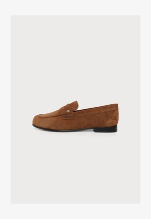Ruskea mokkanahkainen loafer mustalla pohjalla, jossa ommeltu hihna ja pieni metallinen logon yksityiskohta sivulla.