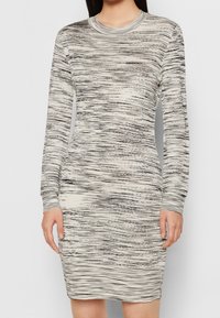 Stickad klänning med lång ärm som har en rund halsringning, texturerade horisontella svarta och krämfärgade ränder, figurnära siluett och ribbade ärmslut.