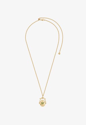 Zlatý reťazový náhrdelník s oválnym príveskom, na ktorom je zelené písmeno „M“ a dekoratívne hviezdičky na bielom pozadí.