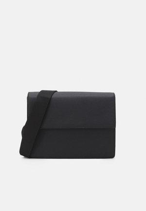 Sac bandoulière noir en matériau texturé avec une fermeture à rabat et une bandoulière. Forme rectangulaire simple avec un design minimaliste.