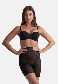 Svart underwire-bh med släta kupor, kombinerad med högmidjade genomskinliga shorts som har ett blommigt spetsmönster och en sömlös design.