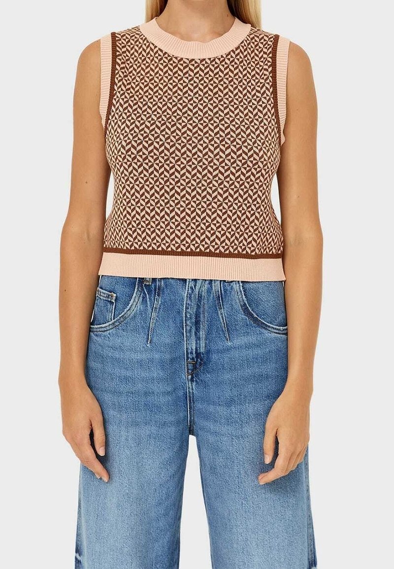 Gestricktes ärmelloses Oberteil in Braun und Pink mit geometrischem Muster, ausgestattet mit einem gerippten Rundhalsausschnitt und passendem Taillenbund, kombiniert mit blauen Jeans.