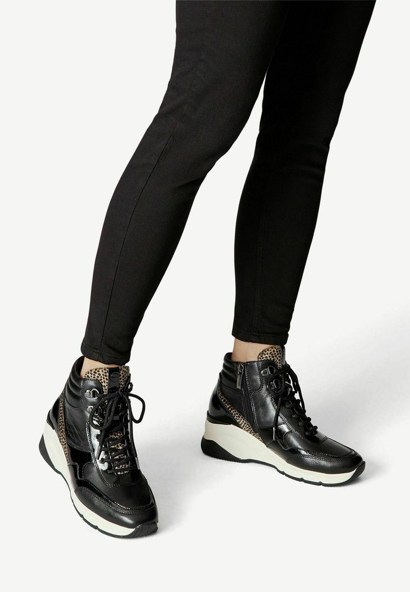 Schwarze High-Top-Sneaker mit beigen Leopardenprint-Akzenten, Schnürung vorne, seitlichem Reißverschluss und einer Keilsohle für zusätzlichen Halt und Höhe.