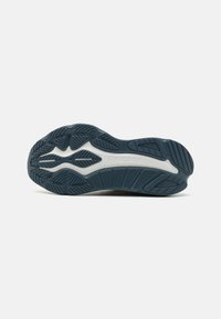 Semelle de chaussure de course, matériau en caoutchouc, couleur bleu foncé, motif de semelle texturé, avec le nom de la marque "Saucony" embossé en blanc.