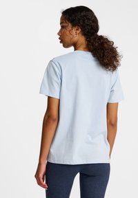 Ljusblå bomullströja med korta ärmar och avslappnad passform, med rund halsringning och mjuk textur. Enkel design, utan mönster eller detaljer.