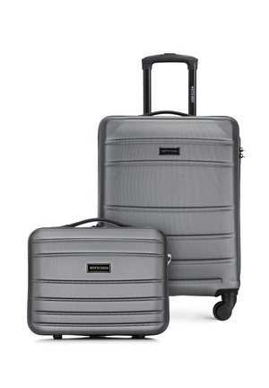 Set aus zwei silbernen Hartschalenkoffern mit horizontalen Rippen, einem großen mit ausziehbarem Griff und Rollen sowie einem kleineren mit oberem Griff.