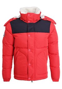 Veste d'hiver rembourrée rouge et noire avec col haut, boutons-pression, fermeture éclair et deux poches frontales, avec un écusson logo sur la manche.