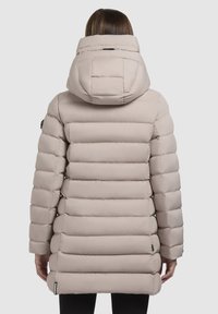 Puffer bunda v světlé béžové barvě, s prošívaným designem, vysokým límcem a kapucí. Hladká textura se bočními kapsami a akcentem loga.