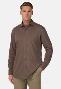 Hnědá košile s dlouhým rukávem a knoflíkovou légou, klasického límce a tmavými knoflíky, vyrobená z měkké tkaniny s hladkým povrchem.
