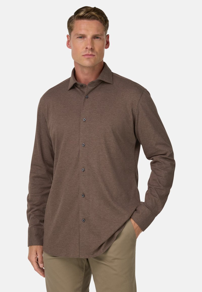 Hnědá košile s dlouhým rukávem a knoflíkovou légou, klasického límce a tmavými knoflíky, vyrobená z měkké tkaniny s hladkým povrchem.