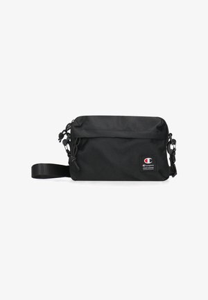 Borsa a tracolla nera in tessuto con forma rettangolare, tracolla regolabile, patch con logo, chiusura a zip e superficie texturizzata.