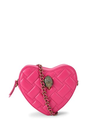 Petit sac matelassé rose vif en forme de cœur avec fermoir décoratif en bronze et bandoulière chaîne assortie sur fond blanc.