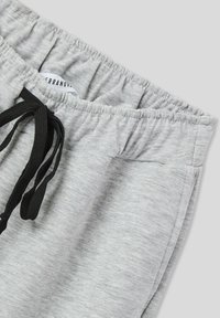 Pantaloni sportivi grigi con elastico in vita, cordoncino nero e design informale. Il tessuto è morbido e presenta una texture melange.
