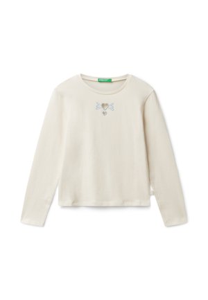 Chemise crème à manches longues avec un col rond et de petits cœurs brodés bleus ainsi que des lignes en forme d'aile centrées sur la poitrine.