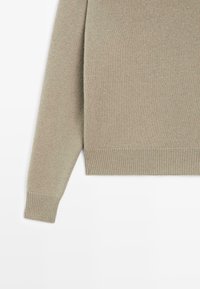 Maglione lavorato a maglia in un verde tenue, con orlo e polsini a costine, caratterizzato da una texture liscia e una vestibilità morbida.