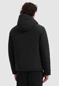 Schwarze gepolsterte Jacke mit Kapuze, die eine glatte Textur und ein minimalistisches Design aufweist. Enthält ein kleines Logo-Detail auf dem Rücken.