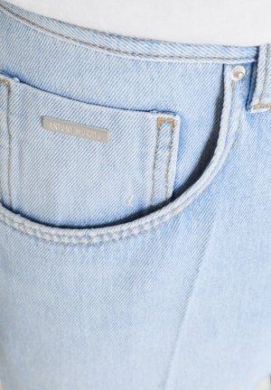 Lichtblauwe spijkerbroekzak met bruine stiksels en een klein metalen label met de tekst "ANTONY MORATO" op de zak.