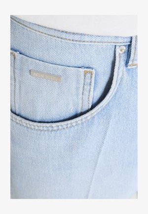 Lichtblauwe spijkerbroekzak met bruine stiksels en een klein metalen label met de tekst "ANTONY MORATO" op de zak.