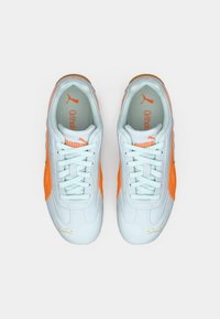 Tênis atléticos brancos e laranja com material de camurça, design com atacadores, colarinho acolchoado e detalhes em logotipo Puma contrastantes.