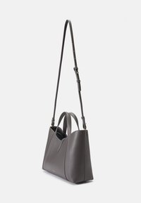 Bolsa de couro cinza com duas alças curtas e uma alça longa ajustável. Apresenta uma forma estruturada e um design minimalista com detalhes de costura.