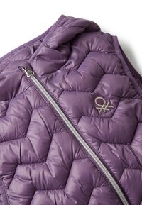 Lila gesteppte Weste mit silbernem Reißverschluss und gesticktem Logo auf der Brust, die Nahaufnahmen von Details und Nähmustern zeigt.