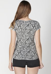 Tricou gri cu flori, cu mâneci scurte, având un model de flori alb-negru. Material moale și un design ajustat, asortat cu pantaloni scurți negri.