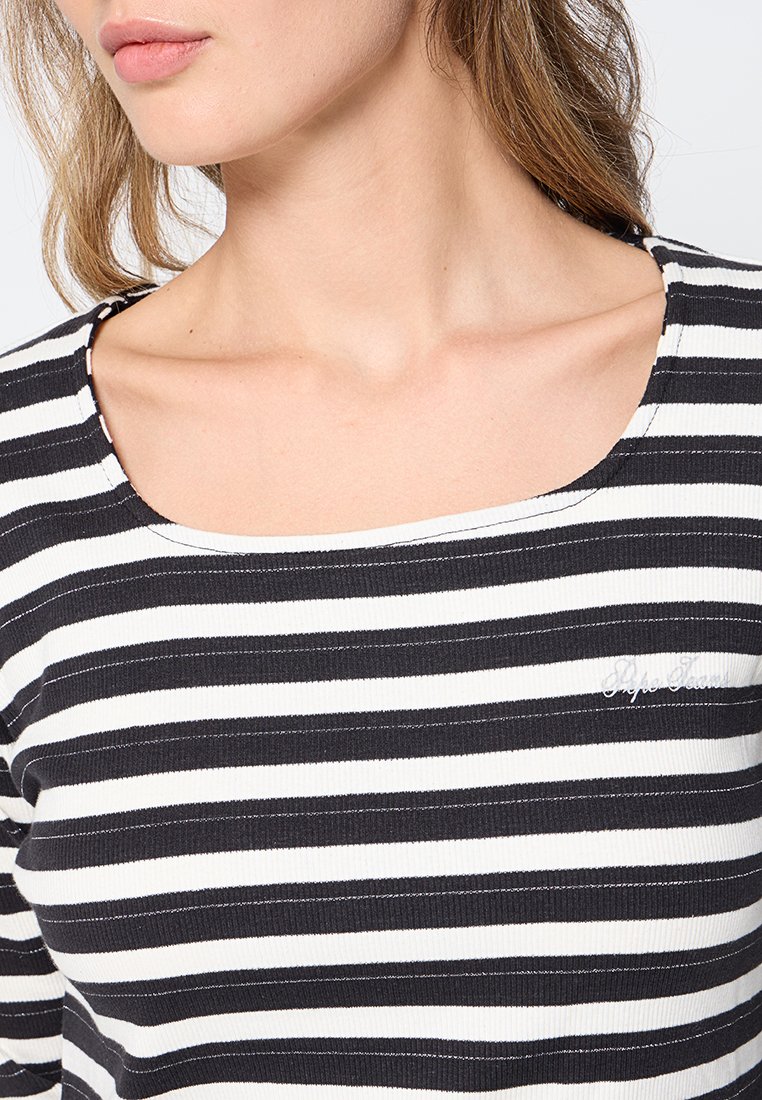 Camiseta de manga corta a rayas blancas y negras con escote cuadrado, textura acanalada y un discreto detalle de logo en el pecho.
