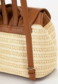 Borsa a tracolla in paglia con accentuazioni e manici in pelle marrone, caratterizzata da una trama testurizzata e una forma strutturata. Inclusa una tracolla regolabile.
