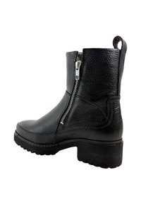 Zwarte leren enkelboot met een gestructureerde afwerking, een zijrits en een dikke hak. Voorzien van een lus voor gemakkelijk aan- en uittrekken.