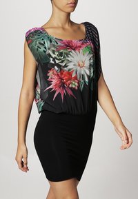 Czarna sukienka z krótkim rękawem w kwiatowy wzór w odcieniach różu, zieleni i bieli. Materiał wydaje się lekki i zwiewny.