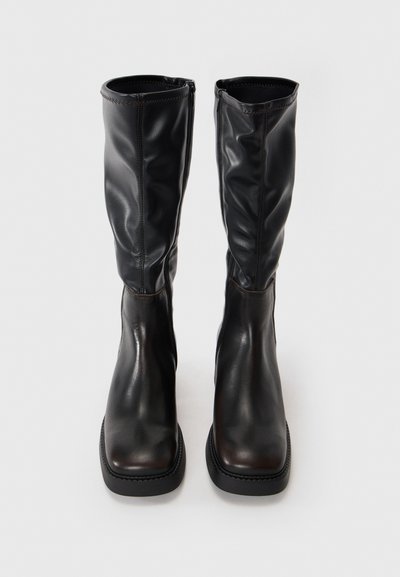 Knee-high black leather boots with a smooth texture, square toe, zip closure, and contrasting stitching at the seams.