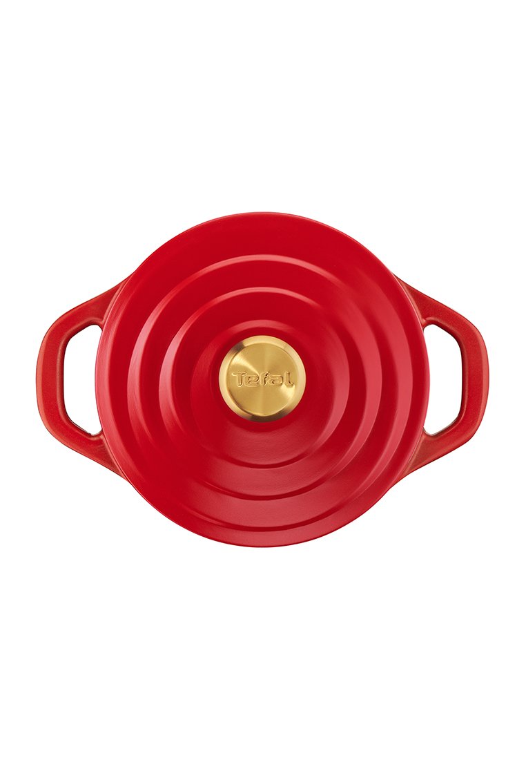 Cocotte ronde en fonte rouge avec deux poignées latérales et un bouton doré gravé de "Tefal" sur le couvercle.