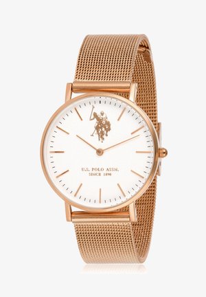 Quadrante bianco rotondo con accenti in oro rosa, cinturino a rete. Presenta un logo di un giocatore di polo, indicatori delle ore sottili e il testo del marchio in basso.