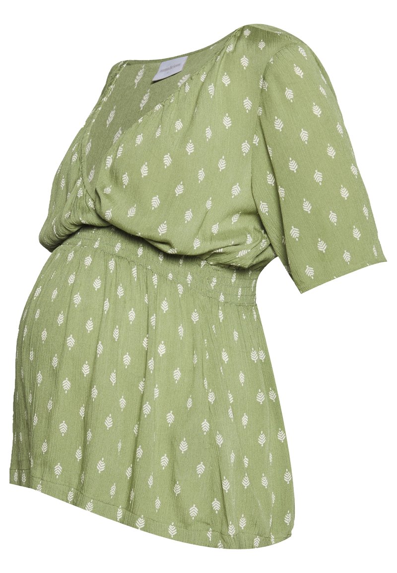 Blusa maternità verde con motivo a foglie bianche, maniche corte, scollo a V e vita elastica arricciata.