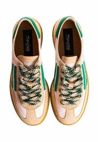 Sneakers beige e bianchi con dettagli verdi. Presentano un tessuto texturizzato, lacci a fantasia e una suola in gomma naturale. Etichetta interna visibile.