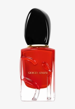 Rode Giorgio Armani nagellakfles met zwarte dop en gouden ringdetail op een witte achtergrond.